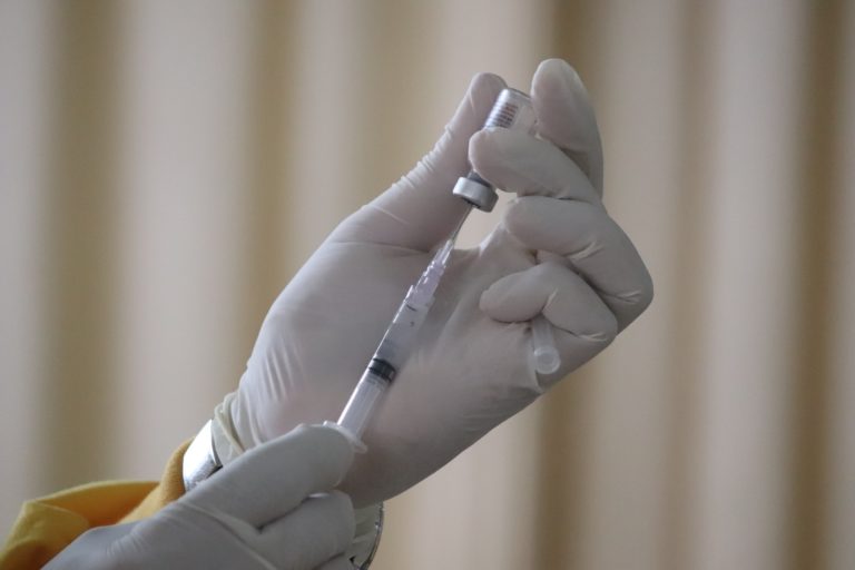 person holding vaccine and syringe